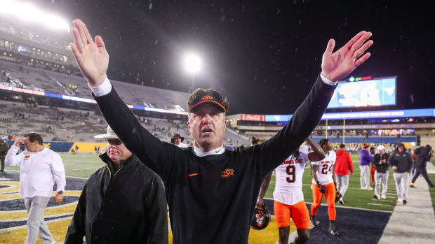 Oct 21, 2023; Morgantown, West Virginia, USA; Oklahoma State Cowboys head coach Mike Gundy celebrates with fans after defeating the West Virginia Mountaineers at Mountaineer Field at Milan Puskar Stadium. Mandatory Credit: Ben Queen-USA TODAY Sports