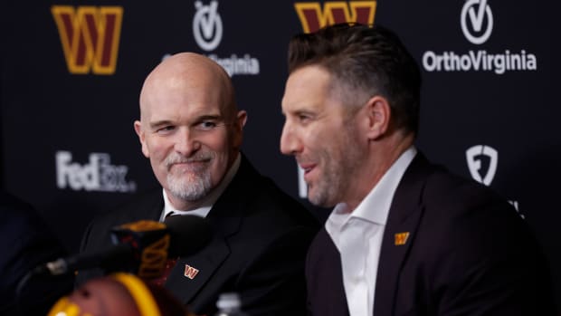 Washington Commanders head coach Dan Quinn (L) smiles as Commanders general manager Adam Peters (R) speaks during Quinn's introductory press conference at Commanders Park. 