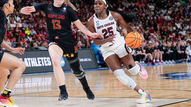 South Carolina Gamecocks guard Raven Johnson dribbles past Maryland Terrapins guard Faith Masonius.