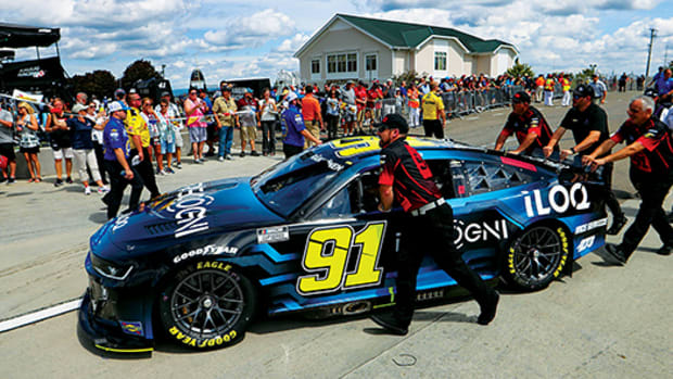 Crew members push the car of NASCAR Cup Series driver Kimi Raikkonen (91) to pit road prior to the Go Bowling at The Glen at Watkins Glen International.