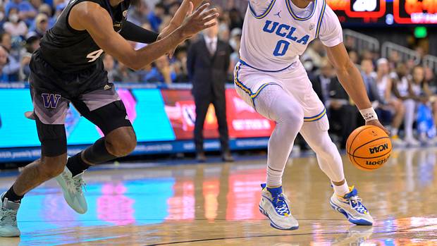 UCLA Bruins guard Jaylen Clark dribbles past Washington Huskies guard PJ Fuller II.
