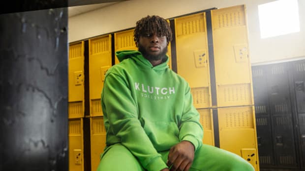 Will Anderson Jr. models a green Klutch sweatsuit in a locker room.