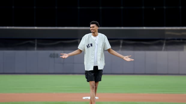 Victor Wembanyama reacts after throwing out the first pitch before a New York Yankees game.