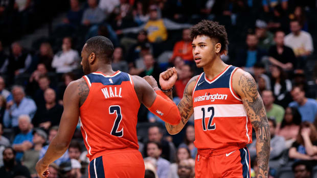 Washington Wizards guard John Wall (2) and forward Kelly Oubre Jr. (12) react after a play in the fourth quarter against the Denver Nuggets at the Pepsi Center.