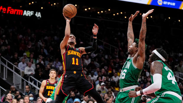 Atlanta Hawks guard Trae Young shoots against Boston Celtics defenders.
