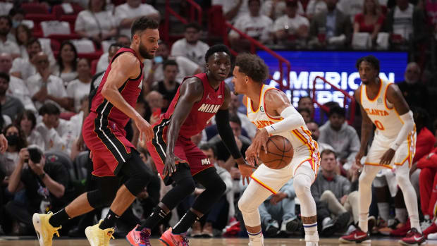 Hawks guard Trae Young dribbles the ball in front of Heat guard Max Strus.