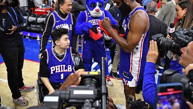 Philadelphia 76ers guard James Harden signs his shoes for a fan after a game.