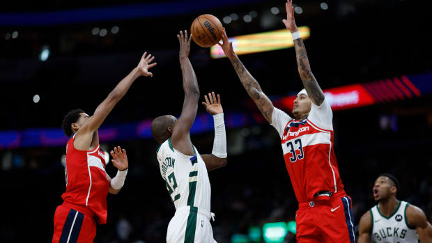 Milwaukee Bucks forward Khris Middleton (22) shoots the ball as Washington Wizards guard Jordan Poole (13) and Wizards forward Kyle Kuzma (33) defend in the fourth quarter at Capital One Arena. Mandatory Credit: Geoff Burke-USA TODAY Sports