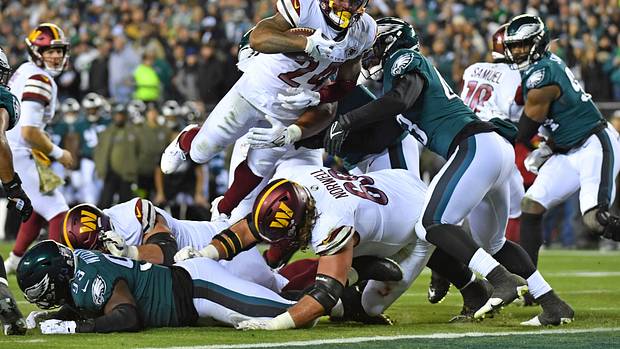 Washington Commanders running back Antonio Gibson leaps into the end zone against the Philadelphia Eagles.
