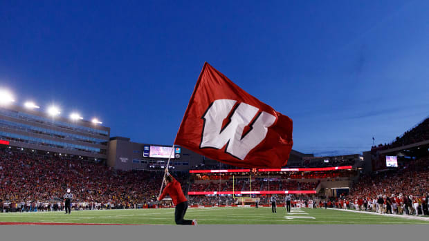 The Wisconsin flag being ran across the end zone at Camp Randall Stadium.