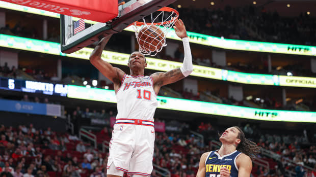 Rockets forward Jabari Smith Jr. dunks the ball as Denver Nuggets forward Aaron Gordon (50) defends during the first quarter at Toyota Center.