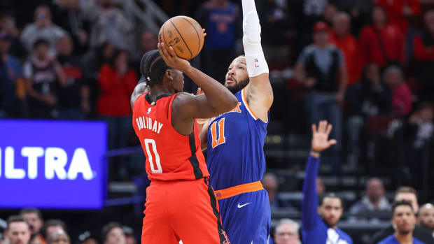 Knicks guard Jalen Brunson (11) fouls Houston Rockets guard Aaron Holiday (0) on a play in the final moments of the fourth quarter at Toyota Center.