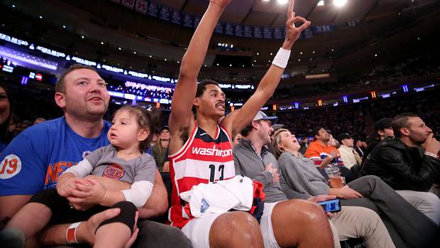 Washington Wizards guard Jordan Poole (13) reacts to a teammate's three point shot as he sits court side with fans during the third quarter against the New York Knicks at Madison Square Garden.