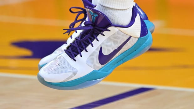 View of white, purple, and teal Nike Kobe shoes.