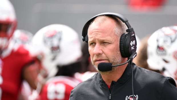 NC State head coach Dave Doeren speaking into his headset.