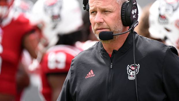 NC State head coach Dave Doeren speaking into his headset.
