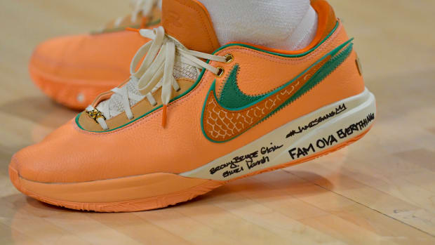 View of LeBron James' orange and green Nike shoes.