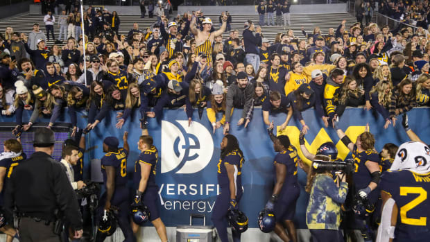 Nov 4, 2023; Morgantown, West Virginia, USA; West Virginia Mountaineers players celebrate with fans after defeating the Brigham Young Cougars at Mountaineer Field at Milan Puskar Stadium. Mandatory Credit: Ben Queen-USA TODAY Sports  