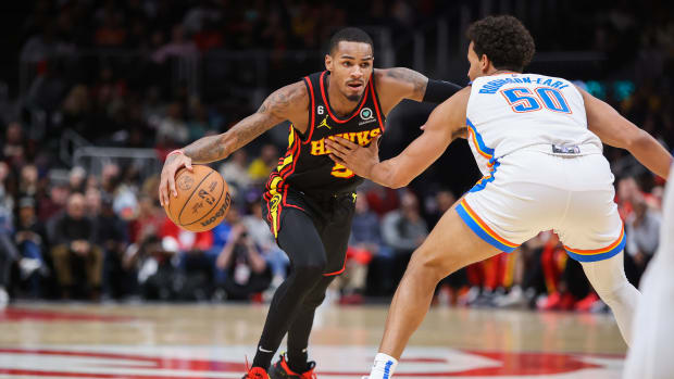 Hawks guard Dejounte Murray dribbles to the basket against the Thunder defense.