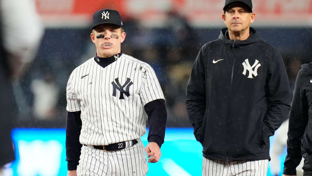 Yankees manager Aaron Boone walks off the field with center fielder Harrison Bader.
