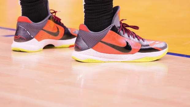 View of orange and black Nike Kobe shoes.