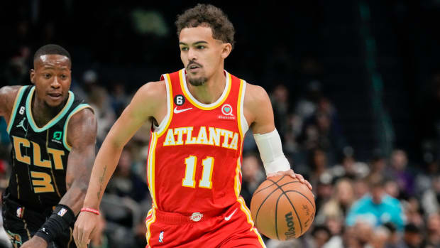 Hawks guard Trae Young dribbles past Hornets guard Terry Rozier.