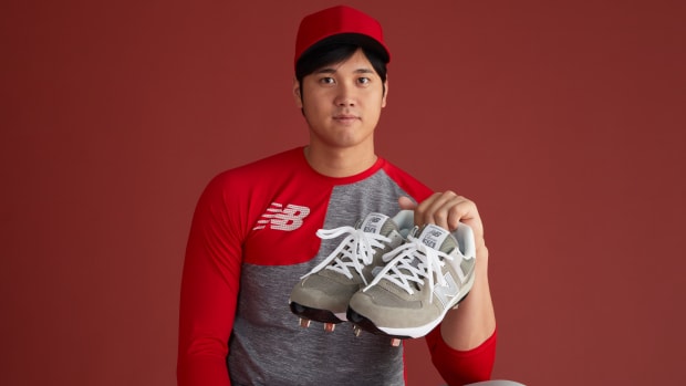 Shohei Ohtani holds grey New Balance cleats.