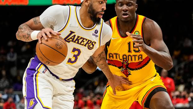 Los Angeles Lakers forward Anthony Davis controls the ball against Atlanta Hawks center Clint Capela. The two teams face off twice in the 2022-23 NBA season.