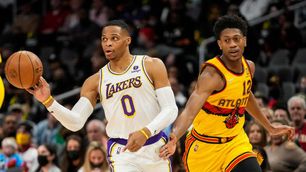 Jan 30, 2022; Atlanta, Georgia, USA; Los Angeles Lakers guard Russell Westbrook (0) passes the ball defended by Atlanta Hawks forward De'Andre Hunter (12) during the first quarter at State Farm Arena.
