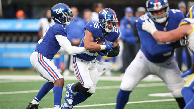 New York Giants quarterback Tyrod Taylor hands the ball off to running back Saquon Barkley.