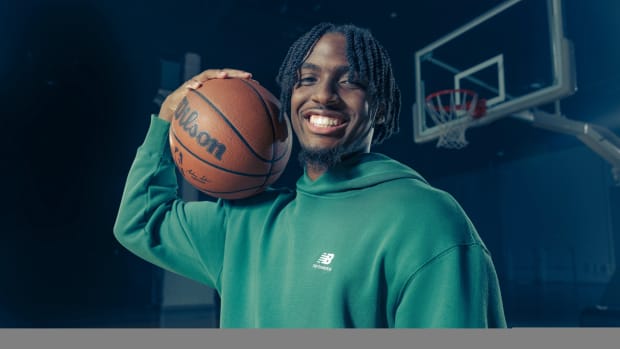 Tyrese Maxey models a green New Balance hoodie.