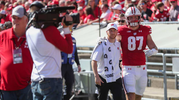 Wisconsin tight end Hayden Rucci being helped to the locker room with an injury.
