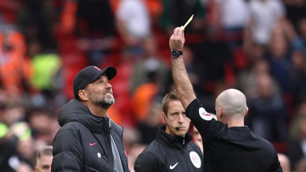 Liverpool manager Jurgen Klopp pictured (left) receiving a yellow card from referee Paul Tierney during a game against Tottenham at Anfield in April 2023