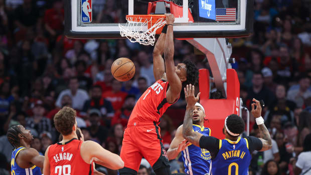 Rockets forward Amen Thompson dunks the ball as Golden State Warriors guard Moses Moody defends during the first quarter at Toyota Center.