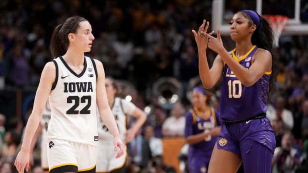 LSU Tigers forward Angel Reese celebrates in front of Iowa Hawkeyes guard Caitlin Clark.