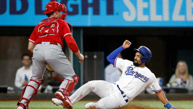 Sep 20, 2022; Arlington, Texas, USA; Texas Rangers second baseman Marcus Semien (2) slides into home plate to score a run as Los Angeles Angels catcher Max Stassi (33) waits for the throw at Globe Life Field. Mandatory Credit: Tim Heitman-USA TODAY Sports
