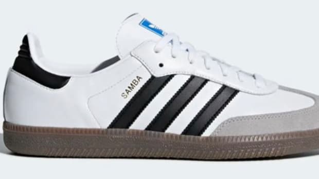 Side view of a white and black adidas shoe.
