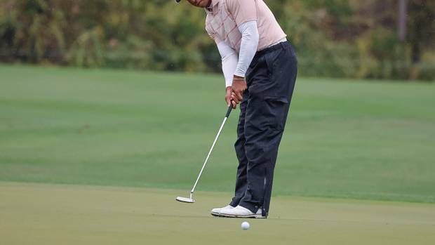 Tiger Woods putts on the fifth green during the PNC Championship.