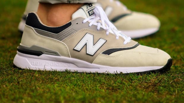 Side view of tan and white New Balance golf shoes.