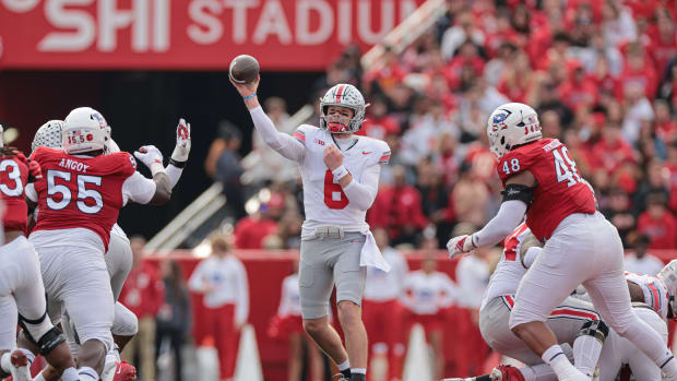Nov 4, 2023; Piscataway, New Jersey, USA; Ohio State Buckeyes quarterback Kyle McCord (6) throws the ball against Rutgers Scarlet Knights defensive lineman Zaire Angoy (55) and defensive lineman Kyonte Hamilton (48) during the first half at SHI Stadium.