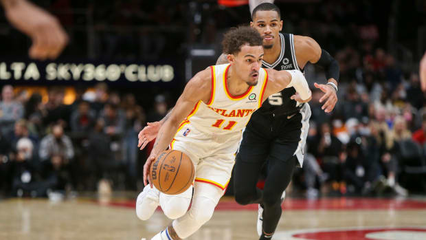 Trae Young dribbles past Dejounte Murray.