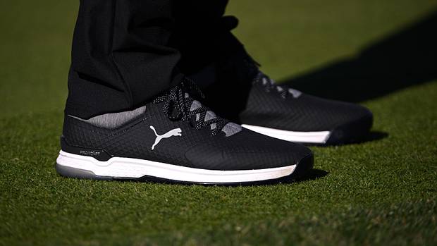 View of Rickie Fowler's black and white PUMA golf shoes.