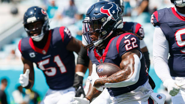 Texans running back Mike Boone runs with the ball with defensive end Will Anderson Jr. behind during the warm-ups against the Jacksonville Jaguars at EverBank Stadium