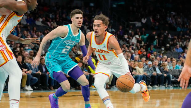 Hawks guard Trae Young dribbles past Hornets guard LaMelo Ball.