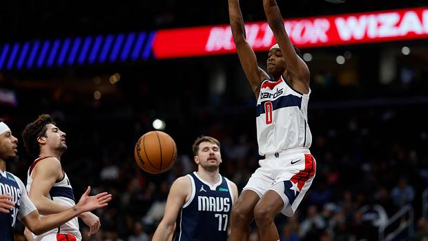 Washington Wizards guard Bilal Coulibaly (0) dunks the ball as Dallas Mavericks guard Luka Doncic (77) looks on in the fourth quarter at Capital One Arena