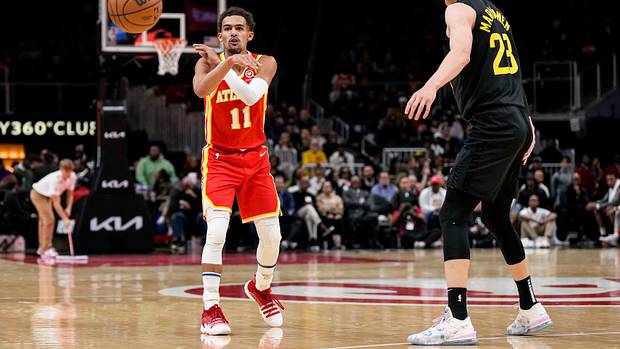 Hawks guard Trae Young passes the ball past Jazz forward Lauri Markkanen.