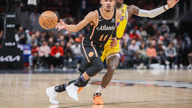 Hawks guard Trae Young passes the ball past Lakers guard Dennis Schroder.