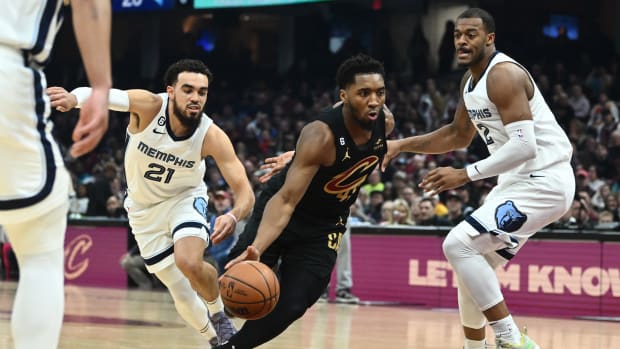 Cleveland Cavaliers guard Donovan Mitchell (45) drives to the basket between Memphis Grizzlies guard Tyus Jones (21) and forward Xavier Tillman (2) during the first half at Rocket Mortgage FieldHouse.