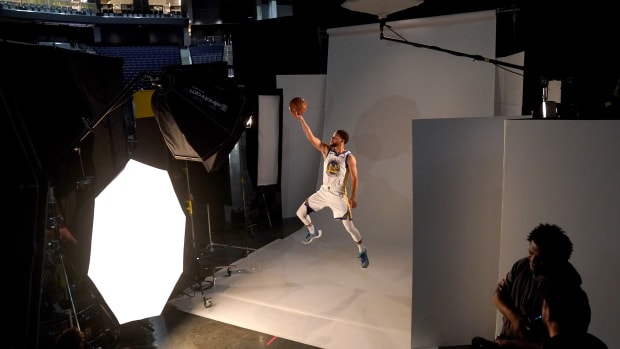 Stephen Curry jumps in the air for a photo shoot.