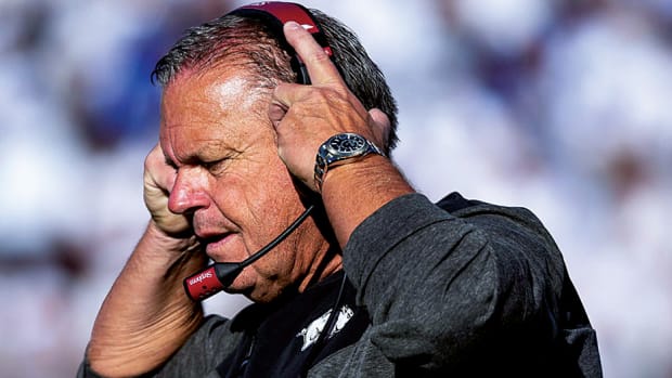 Arkansas coach Sam Pittman tries to hear in his headset during the game in Provo, Utah against BYU. (Gabriel Mayberry – USA TODAY Sports)